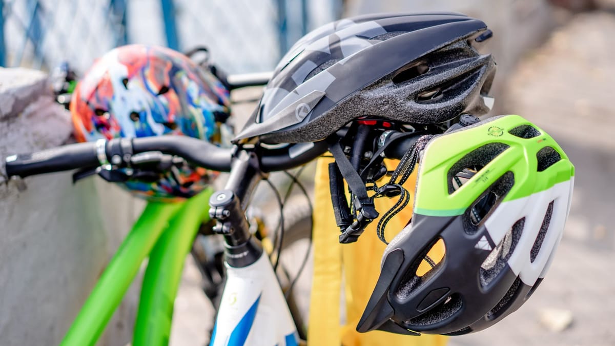 Trois casques de vélo accrochés au guidon d'un vélo