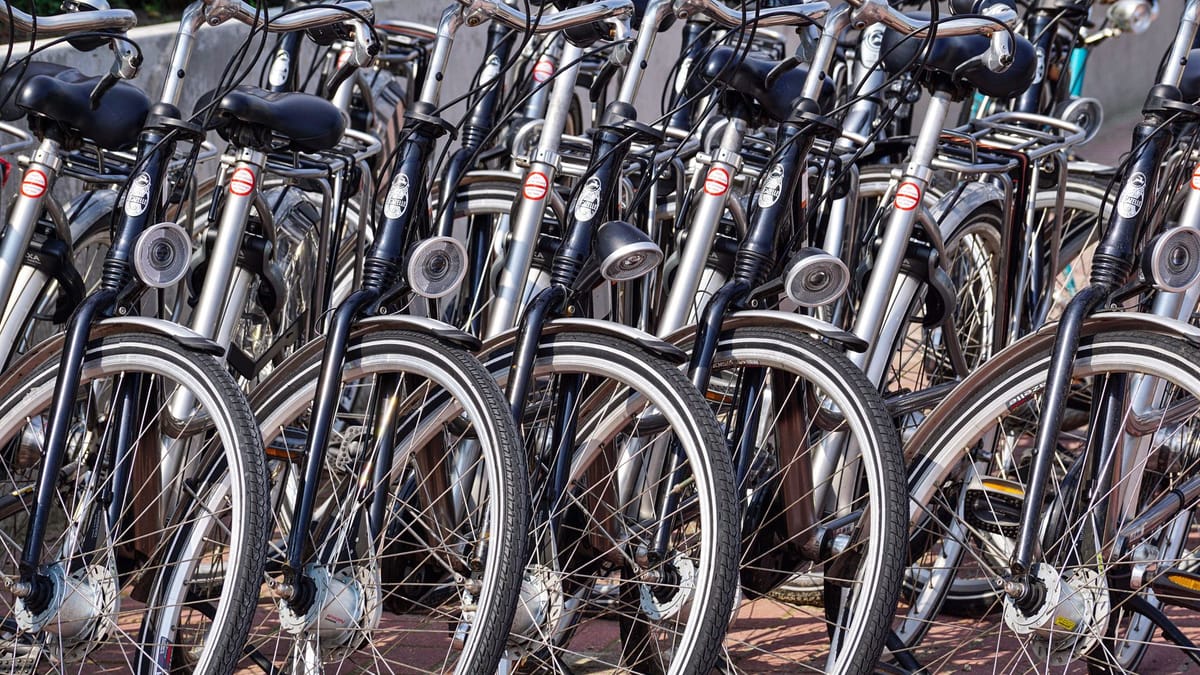 Rangée de vélos de ville alignés roue contre roue, vus de face