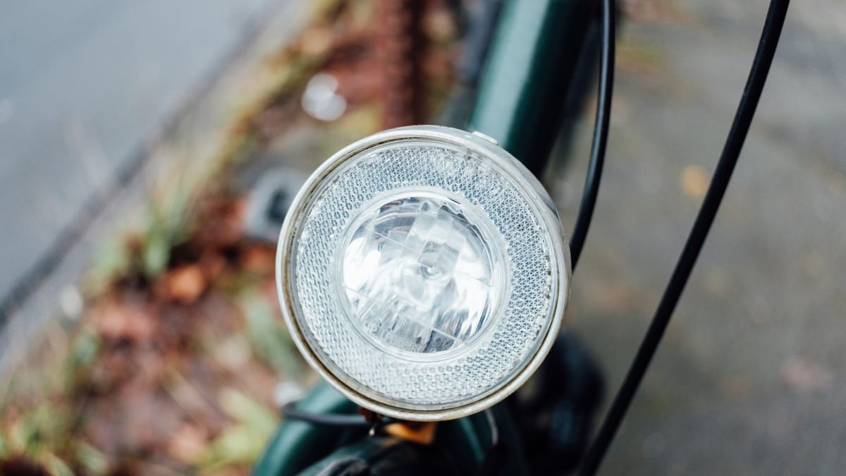 Phare avant rond d'un vélo de ville, vu de près